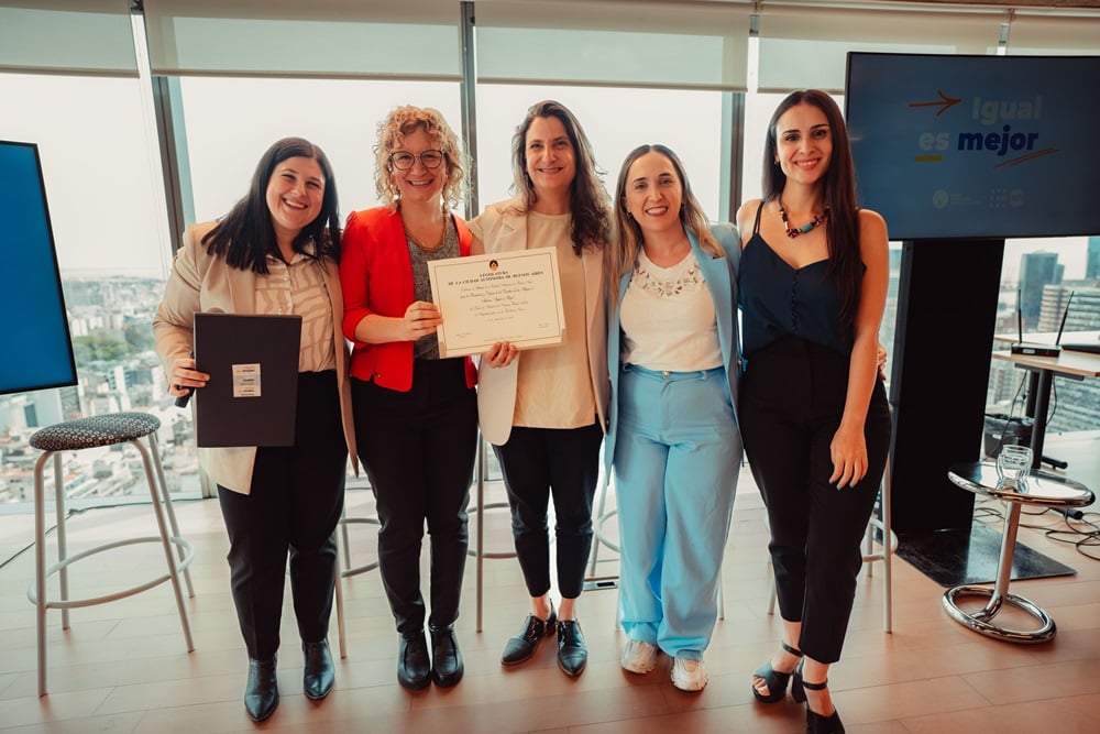 Cinco mujeres posan con un diploma. 