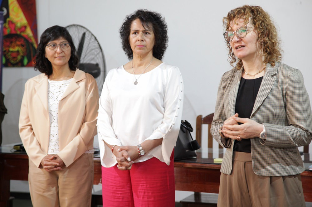 Tres mujeres una al lado de la otra. Una habla al público