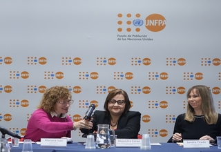 Tres mujeres, representantes de UNFPA y del gobierno de Argentina. De fondo, un panel con logo UNFPA