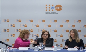 Tres mujeres, representantes de UNFPA y del gobierno de Argentina. De fondo, un panel con logo UNFPA
